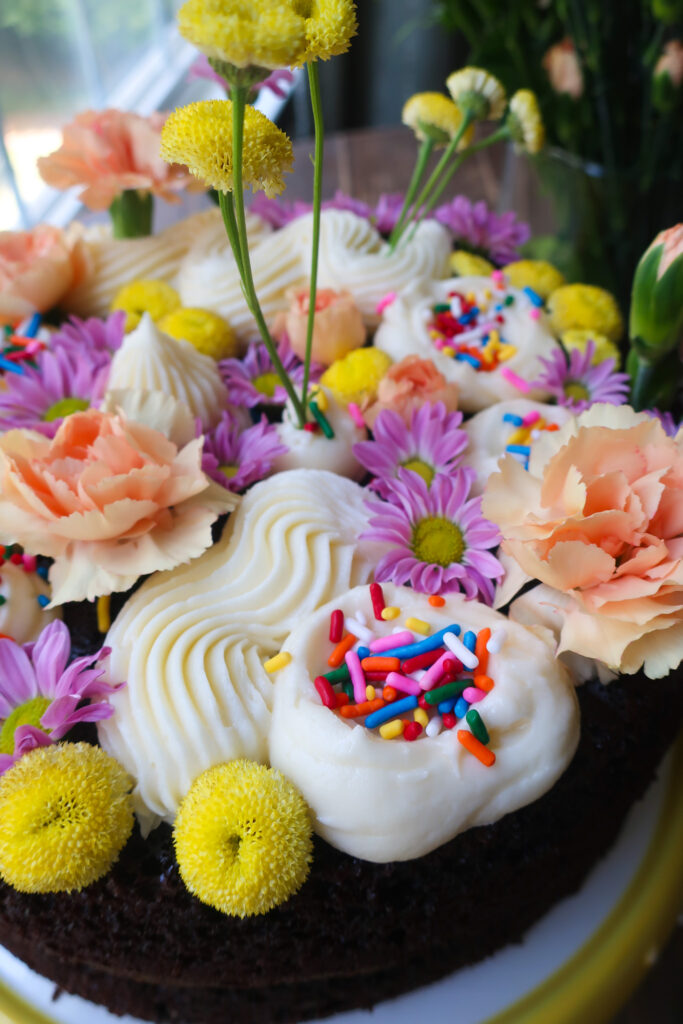 sprinkles and flowers on chocolate vanilla cake