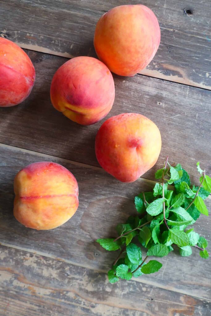 peaches and mint on wooden table