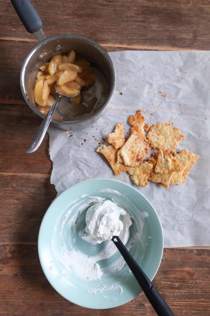 baked pie scraps with spiced cooked apples and whipped cream