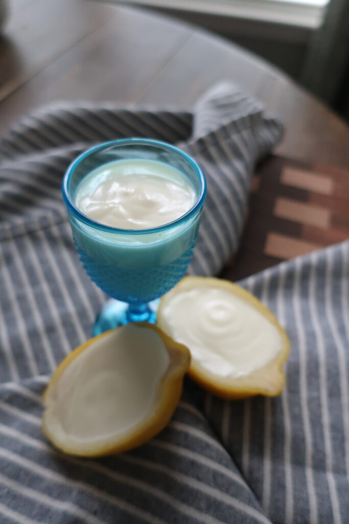 lemon posset; lemon posset in halves of lemon; lemon posset in blue small chalice on striped napkin