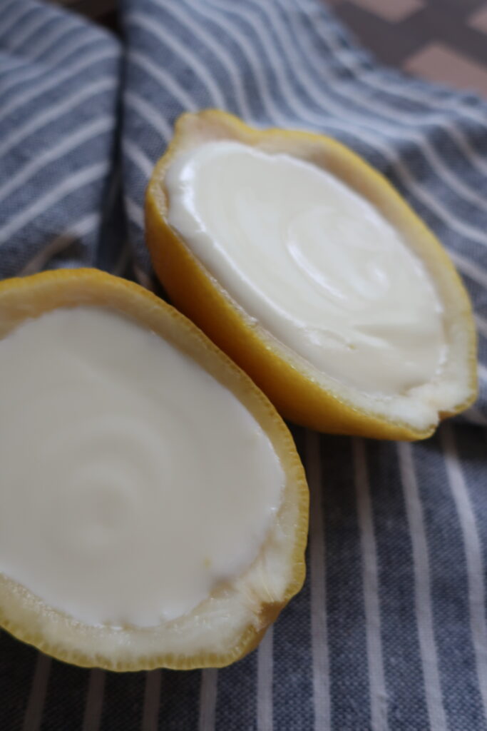 lemon posset; lemon posset in halves of lemon; lemon posset in blue small chalice on striped napkin