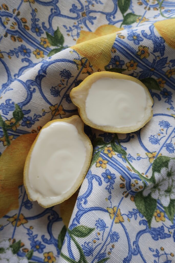 lemon posset; lemon posset in halves of lemon; lemon posset in blue small chalice on striped napkin