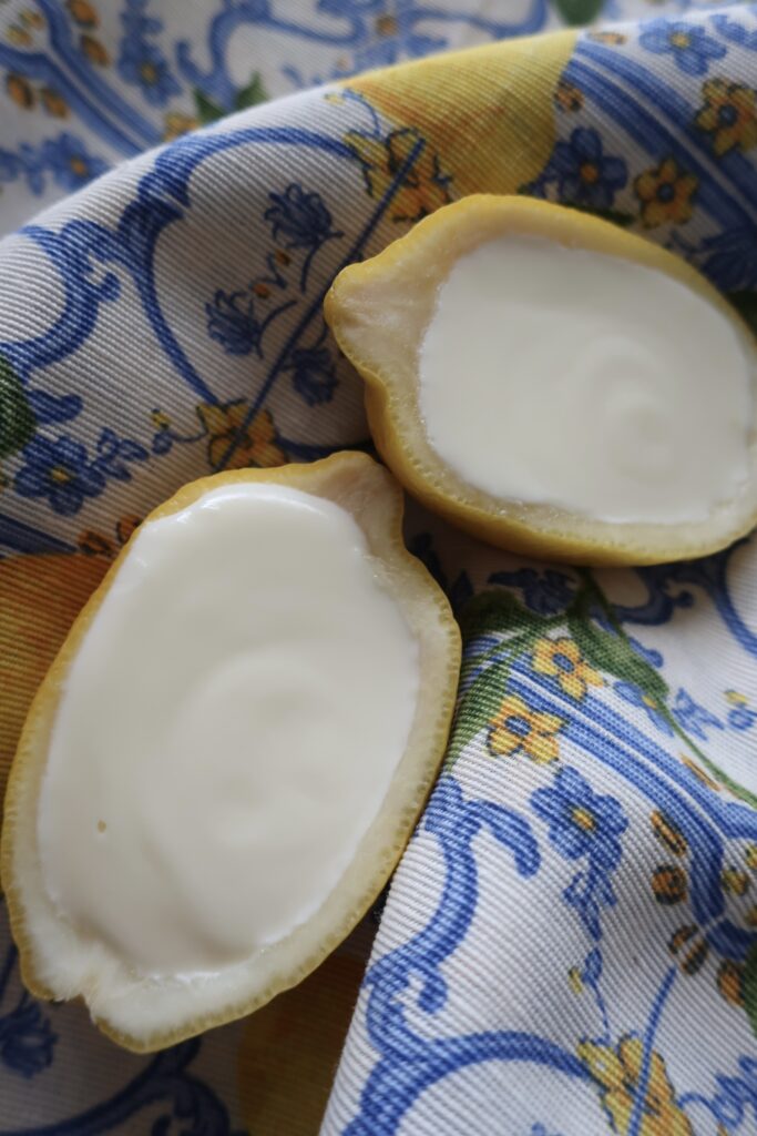 lemon posset; lemon posset in halves of lemon; lemon posset in blue small chalice on striped napkin