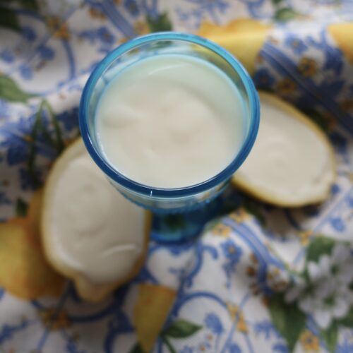 lemon posset; lemon posset in halves of lemon; lemon posset in blue small chalice on striped napkin