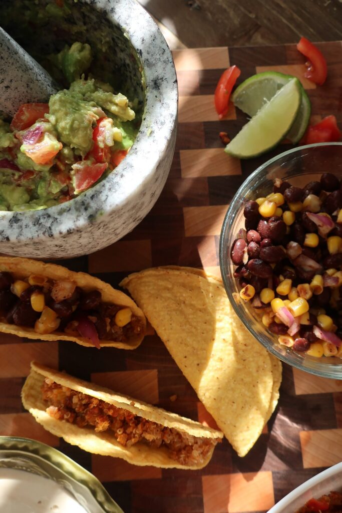 quinoa taco meat for vegan quinoa taco meat with homemade cashew sour cream, and homemade guacamole; guacamole in mortar and pestle