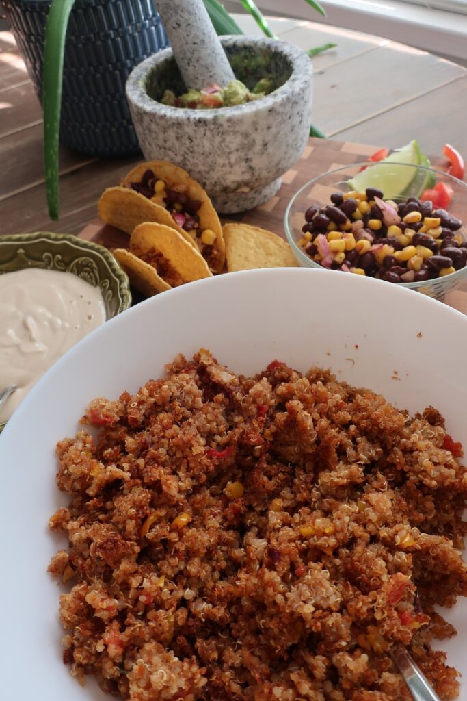 quinoa taco meat for vegan quinoa taco meat with homemade cashew sour cream, and homemade guacamole; guacamole in mortar and pestle