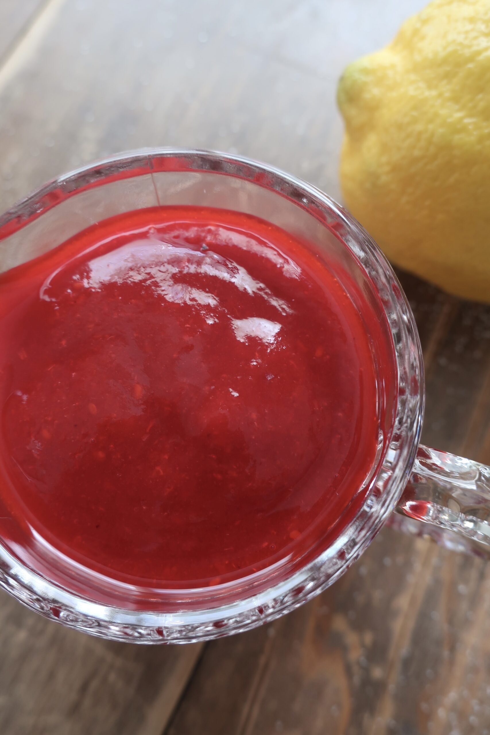 homemade raspberry sauce in small glass pitcher