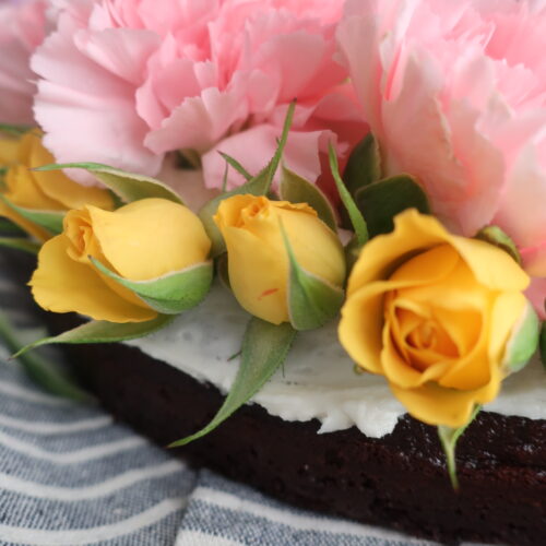 flowers for spring bunny cake; chocolate cake with vanilla buttercream frosting topped with fresh pink, purple, and yellow flowers, shaped like a bunny; bunny cake for easter; easter dessert