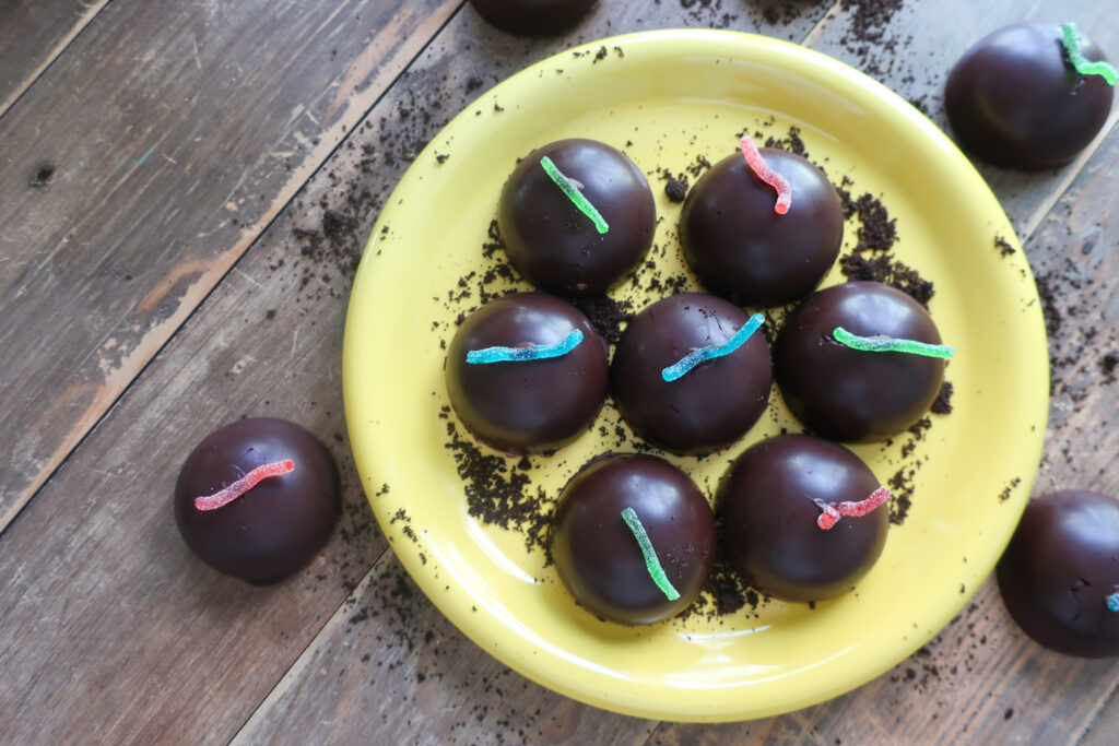 dirt pudding tea cakes; gummy worms; tea cakes on a wooden plate; oreo dessert; halloween dessert; oreo crust