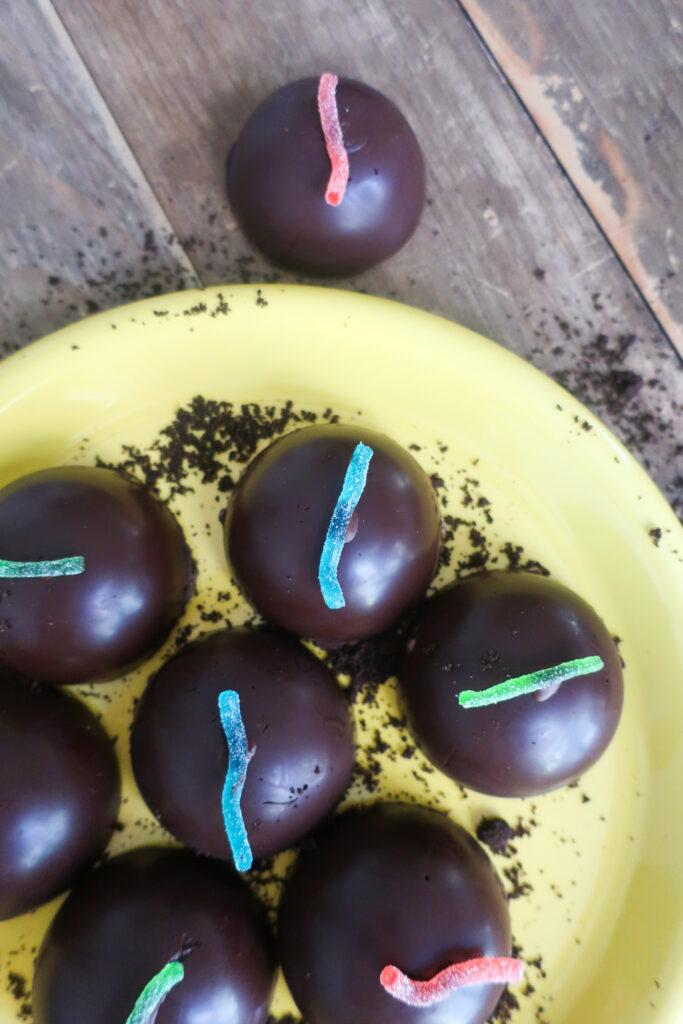 dirt pudding tea cakes; gummy worms; tea cakes on a wooden plate; oreo dessert; halloween dessert; oreo crust