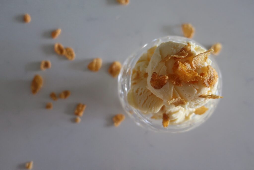 dish of cereal milk ice cream topped with cornflakes