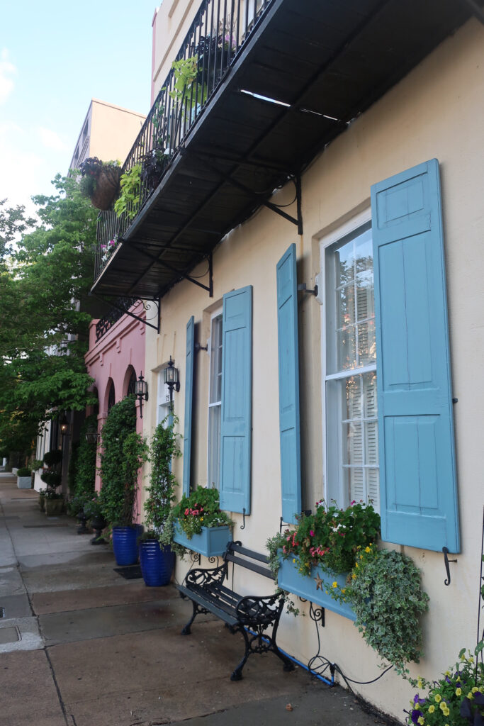 woman on rainbow row in charleston; charleston historic district; things to do in charleston south carolina; visit charleston south carolina; places to see outside of the historic district in charleston south carolina; southern united states state; usa road trip; southern charm; charleston flower boxes; mount pleasant charleston; beach towns; small town usa; daniels island south carolina; daniel island ferry south carolina