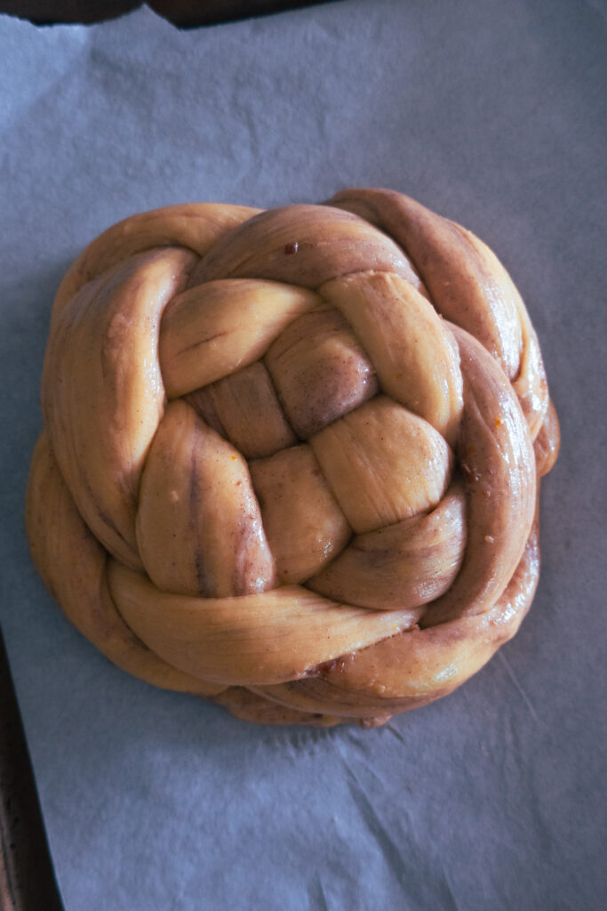 dough formed into knot for spiced challah bread knot; cardamom, cinnamon, date spiced enriched dough