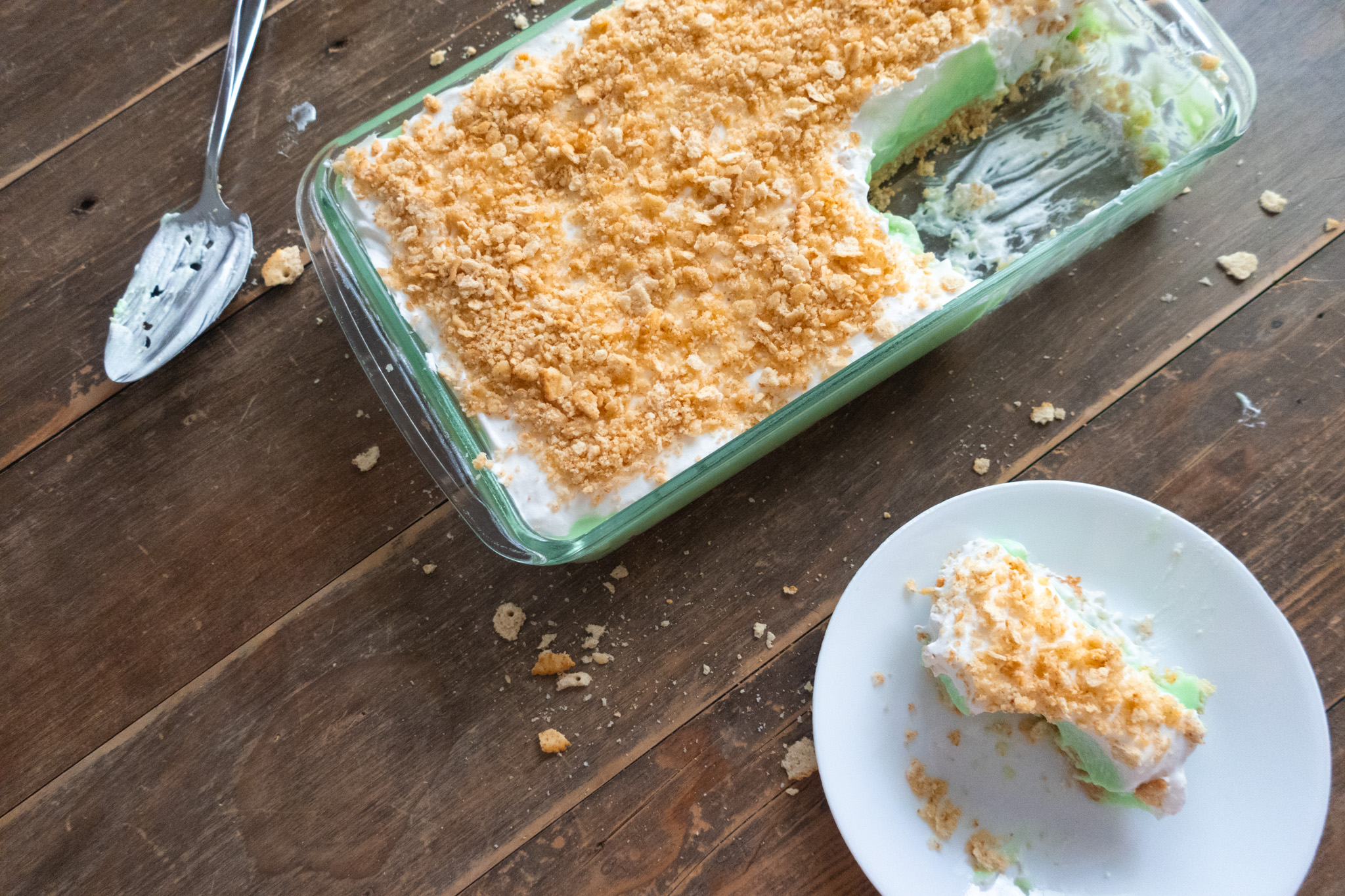 slice of no bake pistachio dessert with pistachio pudding, cool whip, and crushed ritz crackers