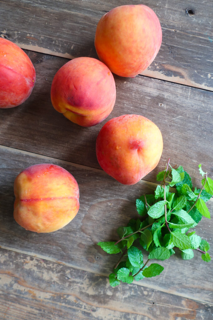 fresh peaches and mint on wooden table for peach and mint compote