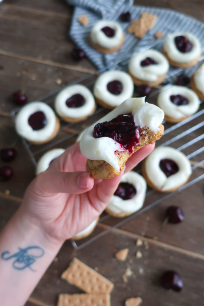 bite / inside look at cherry cheesecake cookies; cream cheese frosting; cherry pie filling; graham cracker cookies