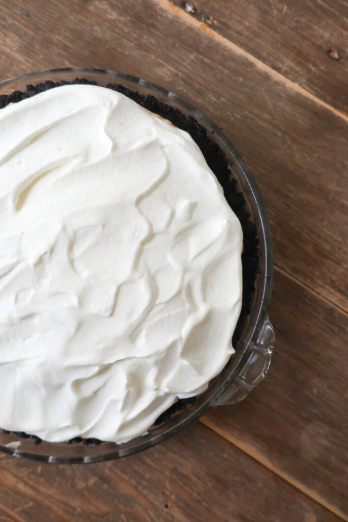 whip cream topping layered on no bake chocolate chip cookie peanut butter pie