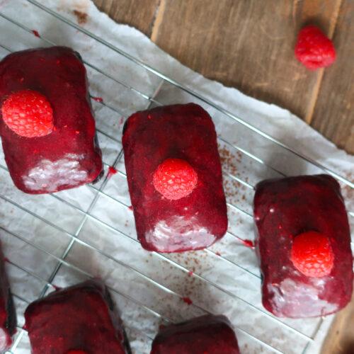 mini chocolate cakes with raspberry glaze topped with a single raspberry