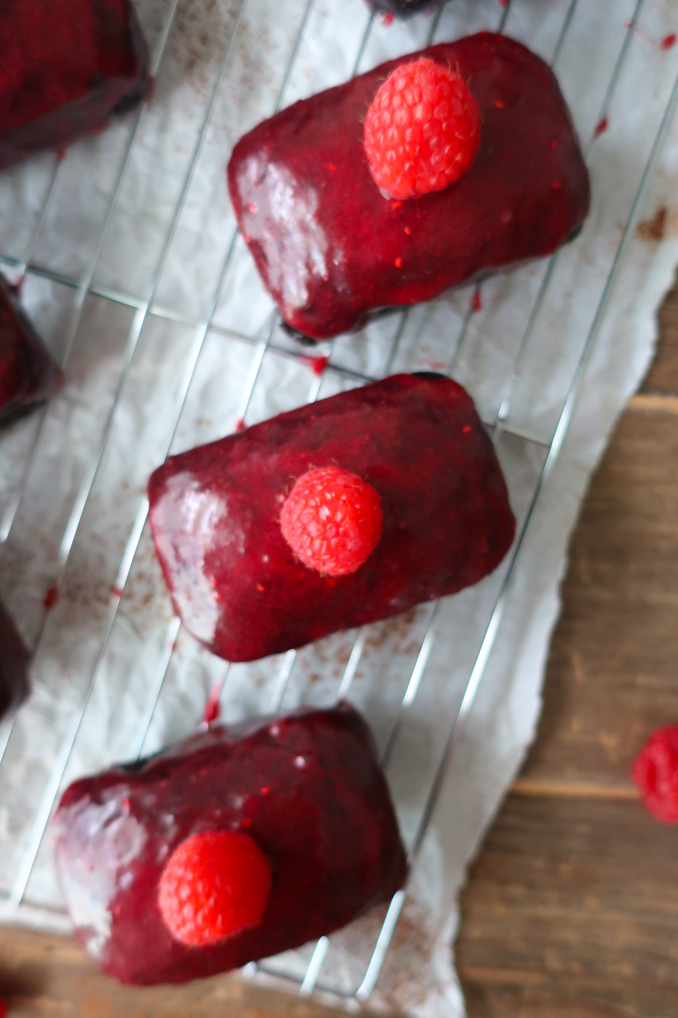 mini chocolate cakes with raspberry glaze topped with a single raspberry