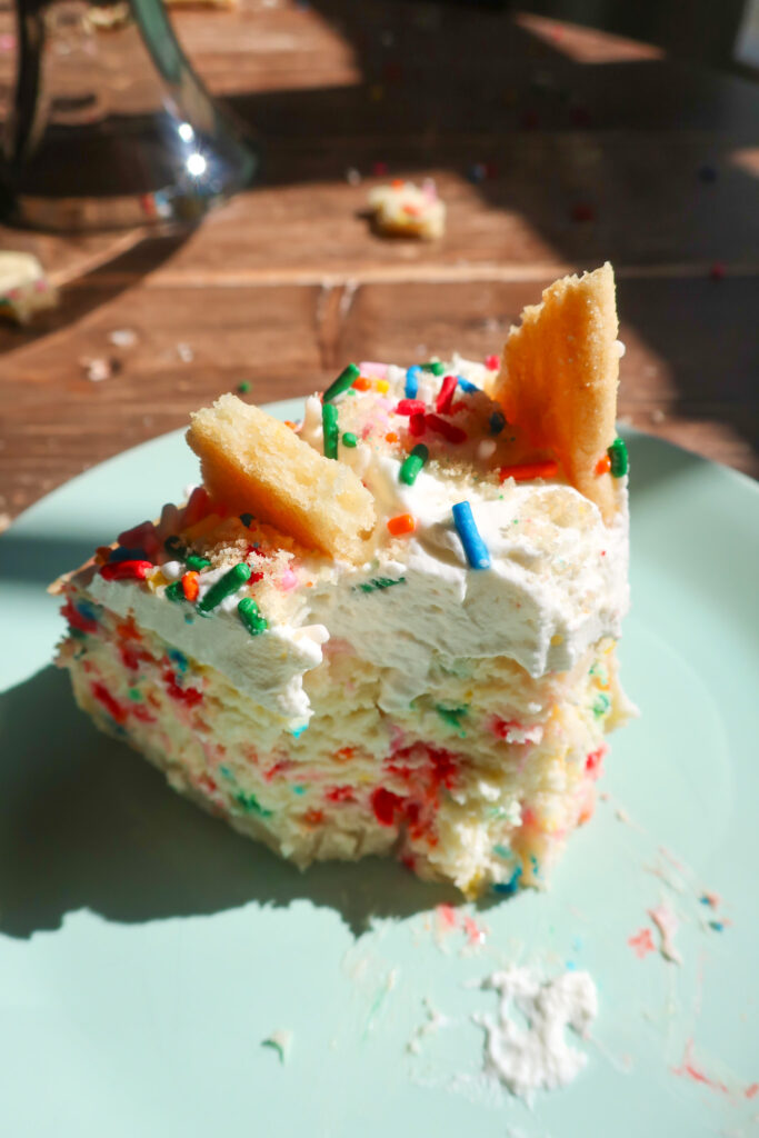 bite of a slice of Funfetti cheesecake with shortbread crust