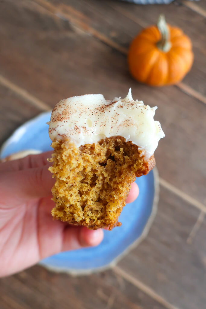 inside/bite of single serve pumpkin cupcakes with cream cheese frosting