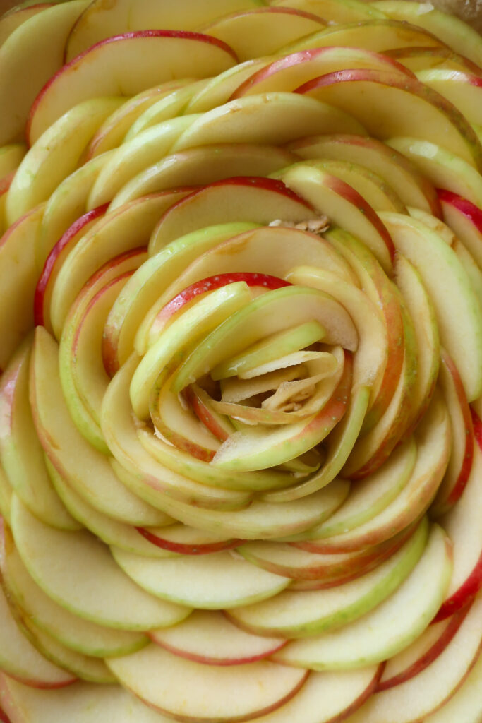 up close of apples in rose shape uncooked inside apple streusel pie