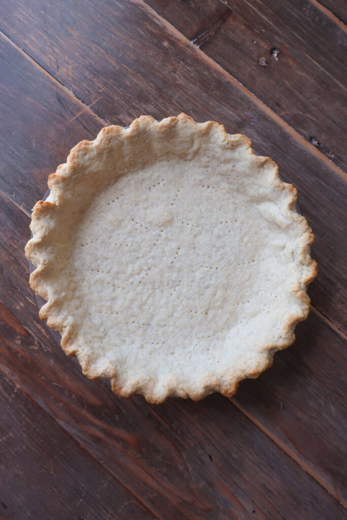 Baked pie crust for chocolate pudding pie with whipped cream topping