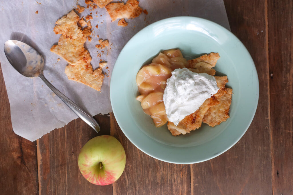 single serve apple scrap pie - cooked apples topped with fresh whipped cream and baked pie crust