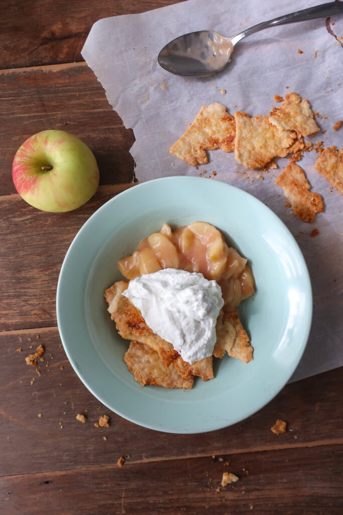 single serve apple scrap pie - cooked apples topped with fresh whipped cream and baked pie crust