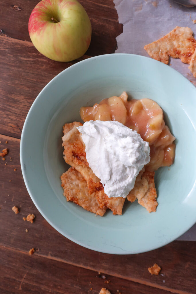 single serve apple scrap pie - cooked apples topped with fresh whipped cream and baked pie crust