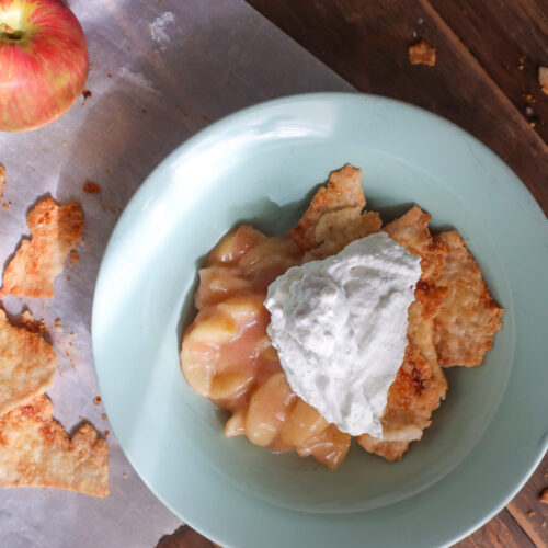 single serve apple scrap pie - cooked apples topped with fresh whipped cream and baked pie crust