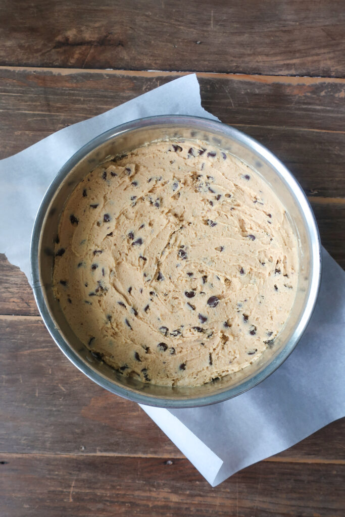 dough in springform pan for peanut butter and chocolate chip cookie cake