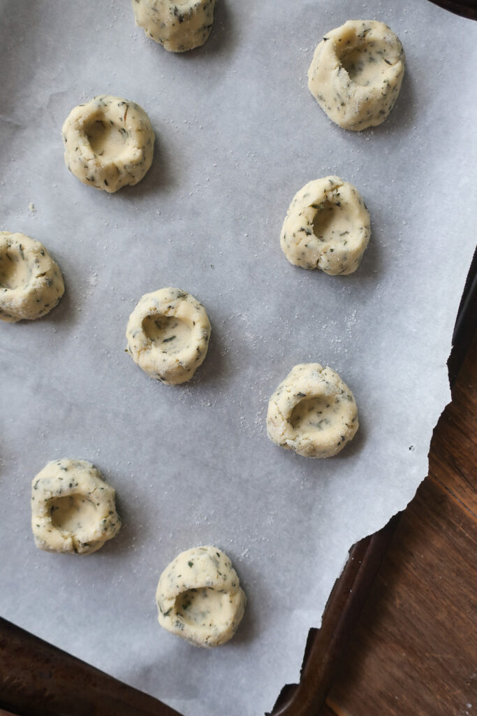 raw rosemary thumbprint cookies on baking tray