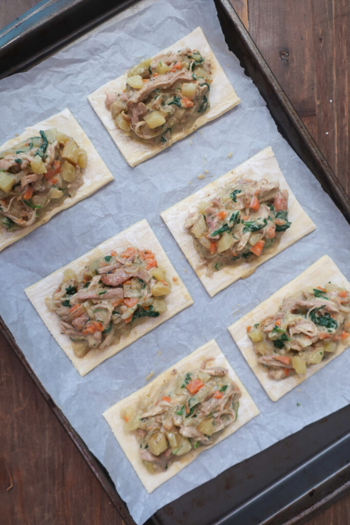 cooked filling for chicken hand pies on cut rectangles of puff pastry