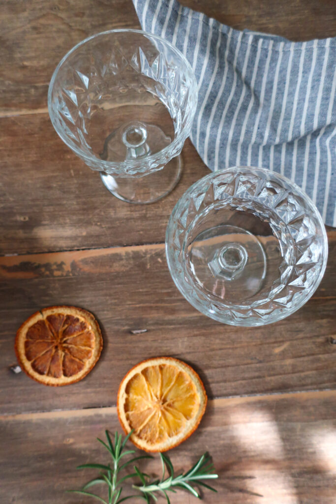 vintage champagne glasses and slices of dehydrated oranges used for mocktail recipe