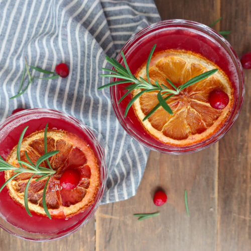 rosemary cranberry mocktails topped with dehydrated oranges, rosemary, and cranberries for decoration