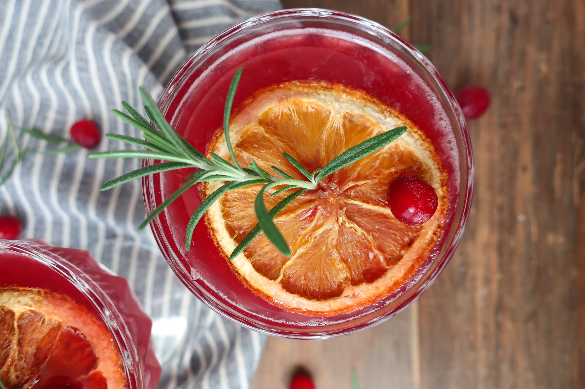 rosemary cranberry mocktails topped with dehydrated oranges, rosemary, and cranberries for decoration