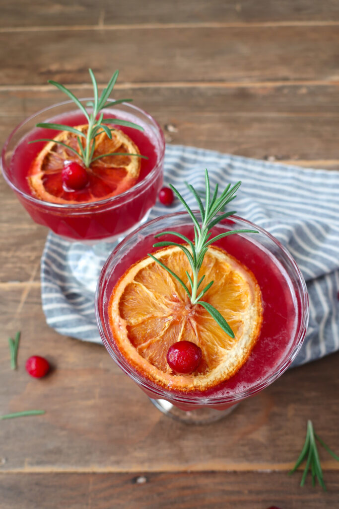 rosemary cranberry mocktails topped with dehydrated oranges, rosemary, and cranberries for decoration