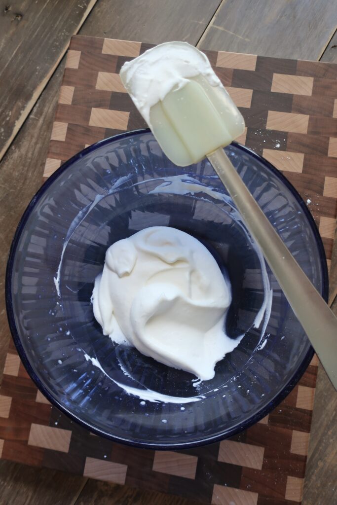 whipped cream; sweetened vanilla cream; chantilly cream; whipped cream in blue bowl with spatula