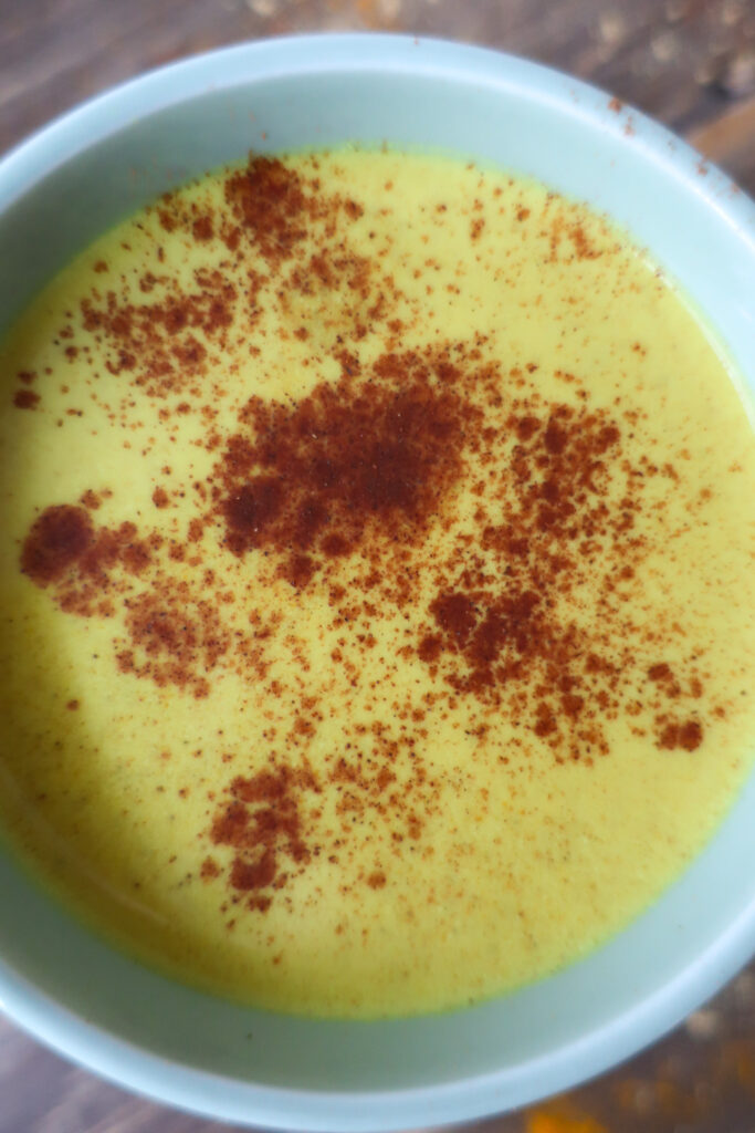 golden turmeric milk tea; golden milk tea; milk tea; immune support drink; antioxidant packed drink; anti-inflammatory drink; spiced tea drink; winter drink; hot drink; drink to fight illness or cold; ginger drink; drink with green tea; cozy winter drink; golden turmeric milk tea topped with a sprinkle of cinnamon