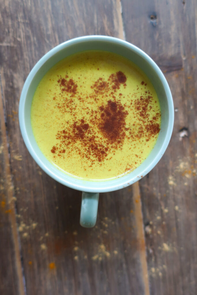 golden turmeric milk tea; golden milk tea; milk tea; immune support drink; antioxidant packed drink; anti-inflammatory drink; spiced tea drink; winter drink; hot drink; drink to fight illness or cold; ginger drink; drink with green tea; cozy winter drink; golden turmeric milk tea topped with a sprinkle of cinnamon