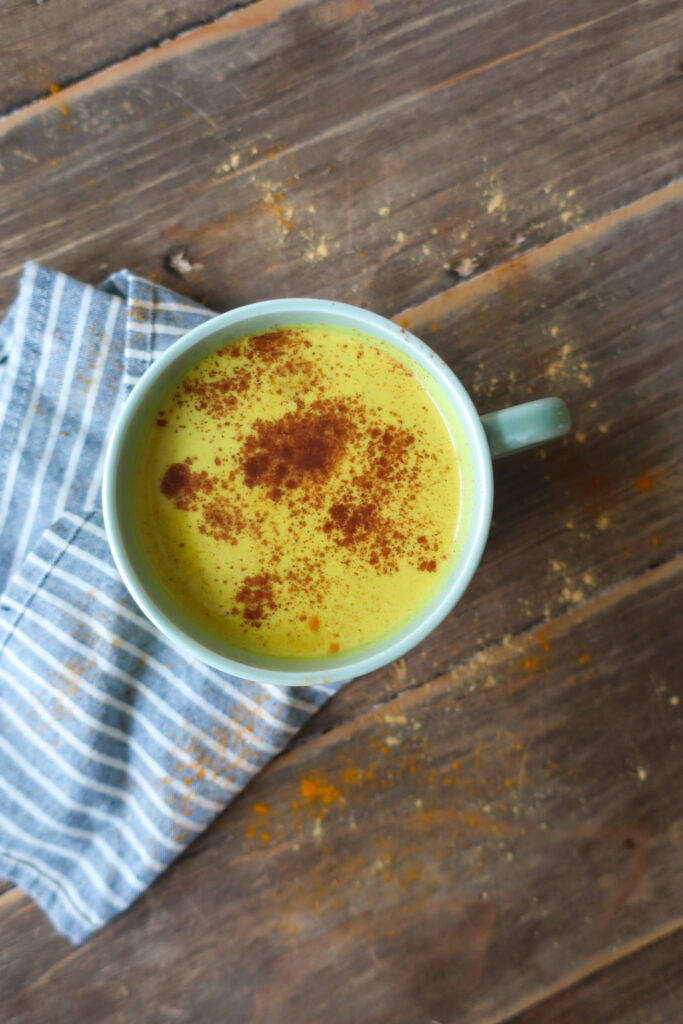 golden turmeric milk tea; golden milk tea; milk tea; immune support drink; antioxidant packed drink; anti-inflammatory drink; spiced tea drink; winter drink; hot drink; drink to fight illness or cold; ginger drink; drink with green tea; cozy winter drink; golden turmeric milk tea topped with a sprinkle of cinnamon