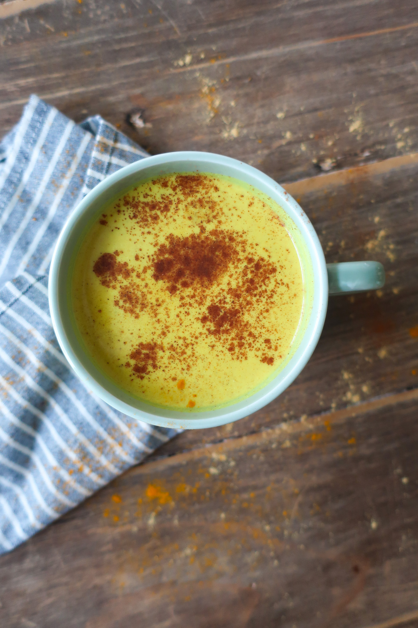 golden turmeric milk tea; golden milk tea; milk tea; immune support drink; antioxidant packed drink; anti-inflammatory drink; spiced tea drink; winter drink; hot drink; drink to fight illness or cold; ginger drink; drink with green tea; cozy winter drink; golden turmeric milk tea topped with a sprinkle of cinnamon