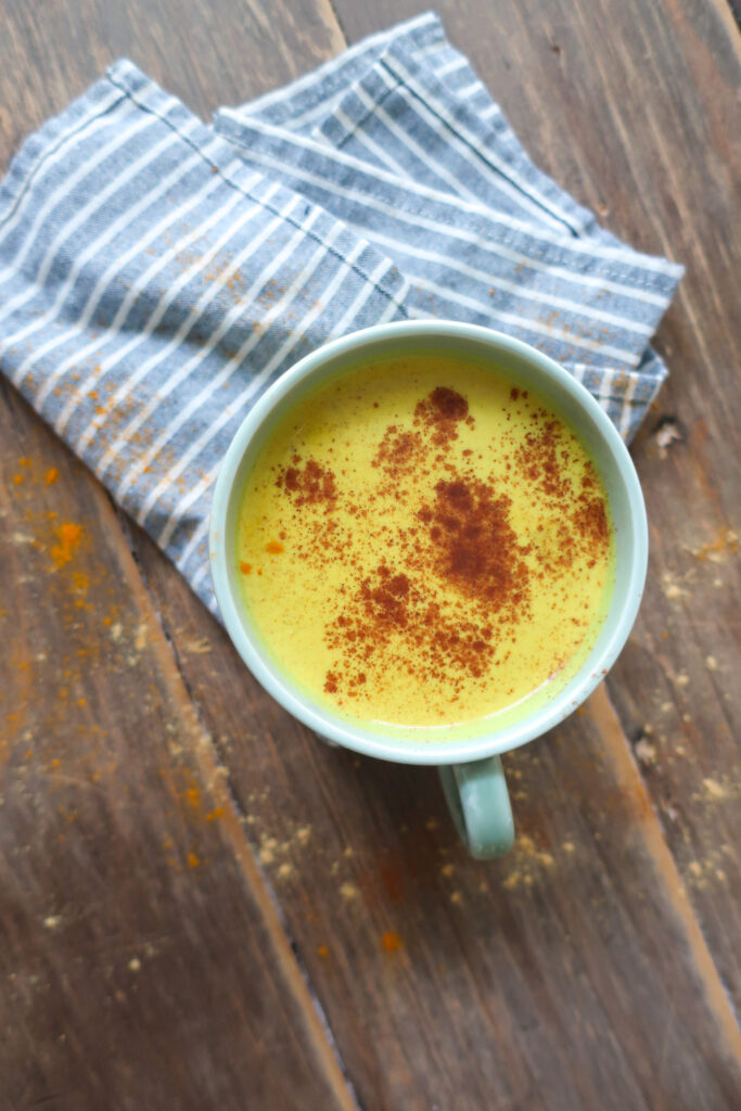 golden turmeric milk tea; golden milk tea; milk tea; immune support drink; antioxidant packed drink; anti-inflammatory drink; spiced tea drink; winter drink; hot drink; drink to fight illness or cold; ginger drink; drink with green tea; cozy winter drink; golden turmeric milk tea topped with a sprinkle of cinnamon