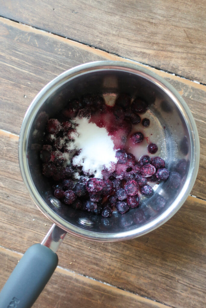 how to make blueberry compote, blueberries sugar and orange juice in a pot, blueberry compote to pair with blueberry muffins, blueberry chai spiced muffins with blueberry compote