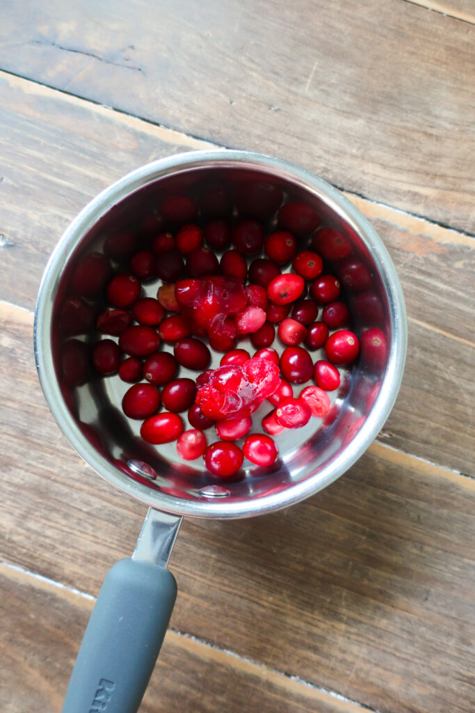 cranberries in pot, mini graham cracker crust, graham cracker crust in mini cast iron skillet, graham cracker crust for single serve cranberry pie with fresh whipped cream topping, cranberry compote, single serve dessert, single serve pie