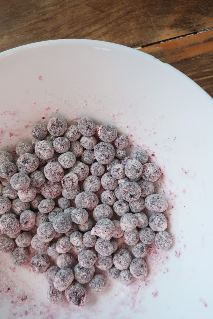 blueberries tossed in flour for muffins, how to make blueberry compote, blueberry compote to pair with blueberry muffins, blueberry chai spiced muffins with blueberry compote