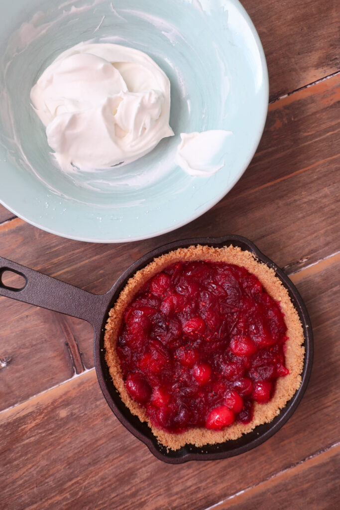 fresh whipped cream in bowl, mini graham cracker crust, graham cracker crust in mini cast iron skillet, graham cracker crust for single serve cranberry pie with fresh whipped cream topping, cranberry compote, single serve dessert, single serve pie