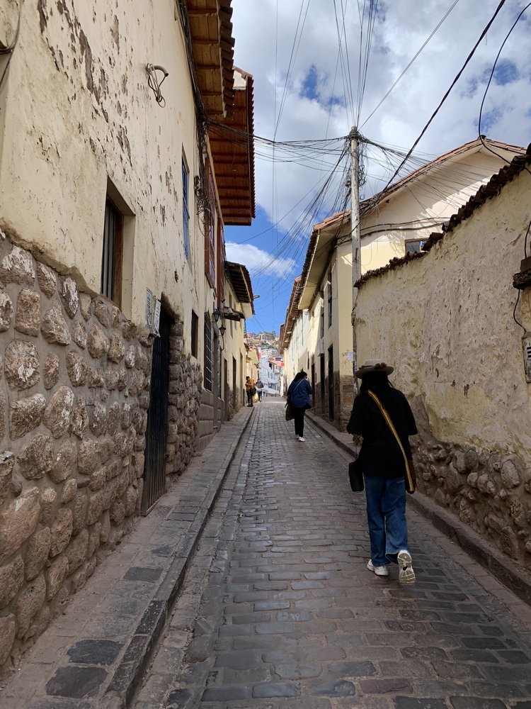 walking up cobblestone street in cusco in peru, south america; solo female travel; solo backpacking; backpacking south america; backpacking tips; peru itinerary;