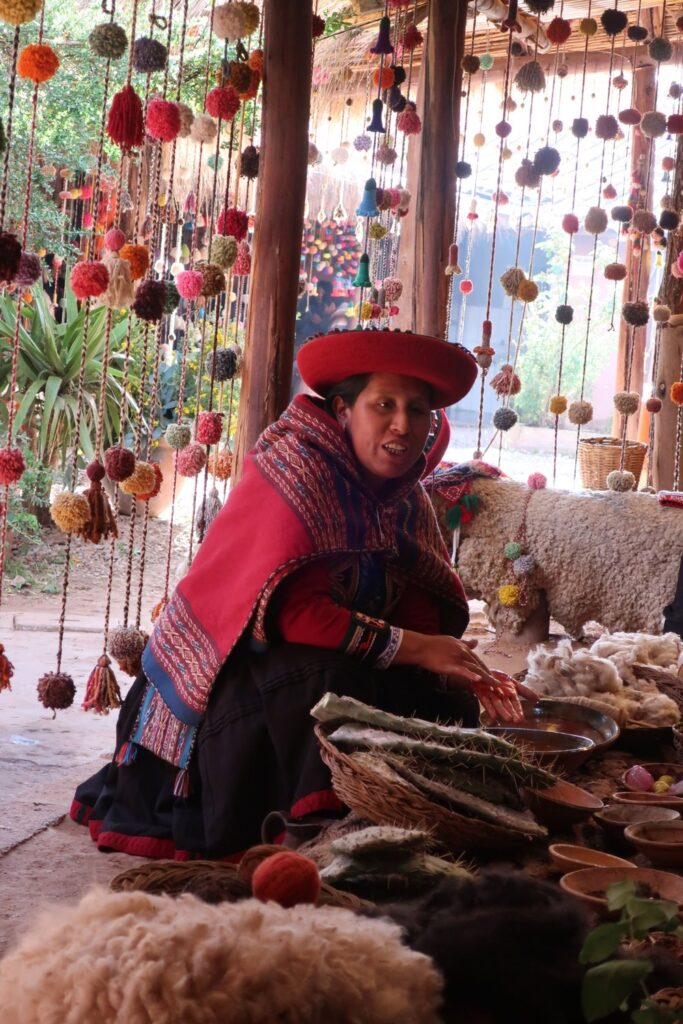 peruvian woman explaining natural textiles in the sacred valley in peru, south america; solo female travel; solo backpacking; backpacking south america; backpacking tips; peru itinerary;